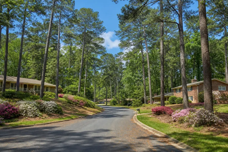 Ranch homes beneath tall pines on a winding street in Peyton Forest.